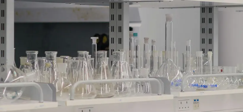 Verrerie de laboratoire alignée sur des étagères : fioles, éprouvettes et béchers